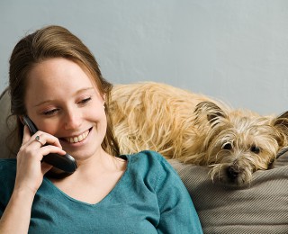 Do We Spend Too Much Time With Dogs? A woman keeps her dog company whilst on the phone