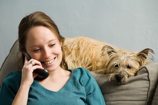 A woman keeps her dog company whilst on the phone